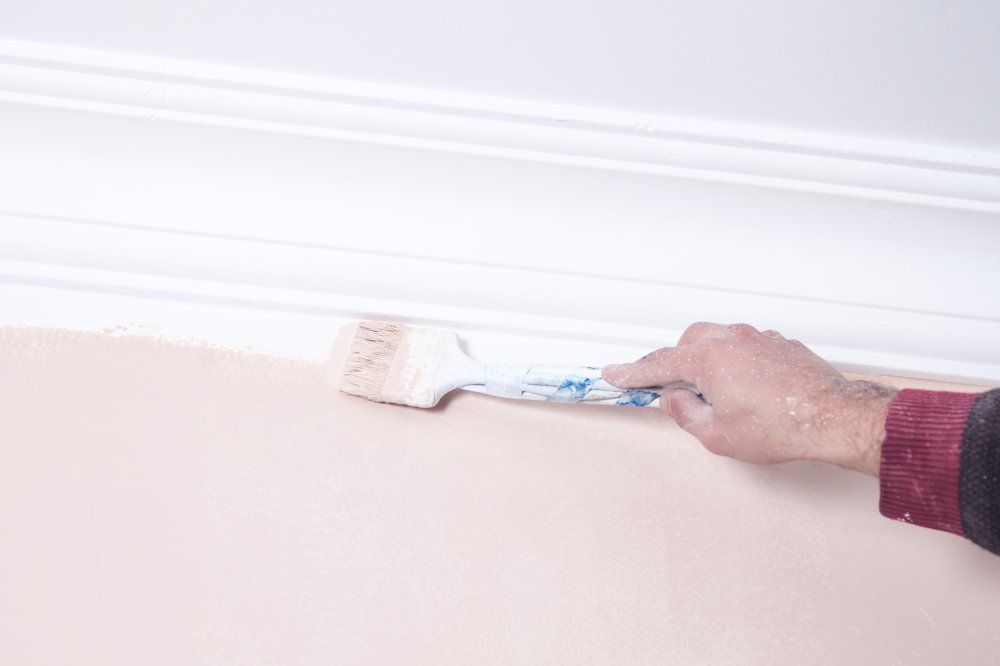 Mann, der mit einem Pinsel eine Wand streicht.